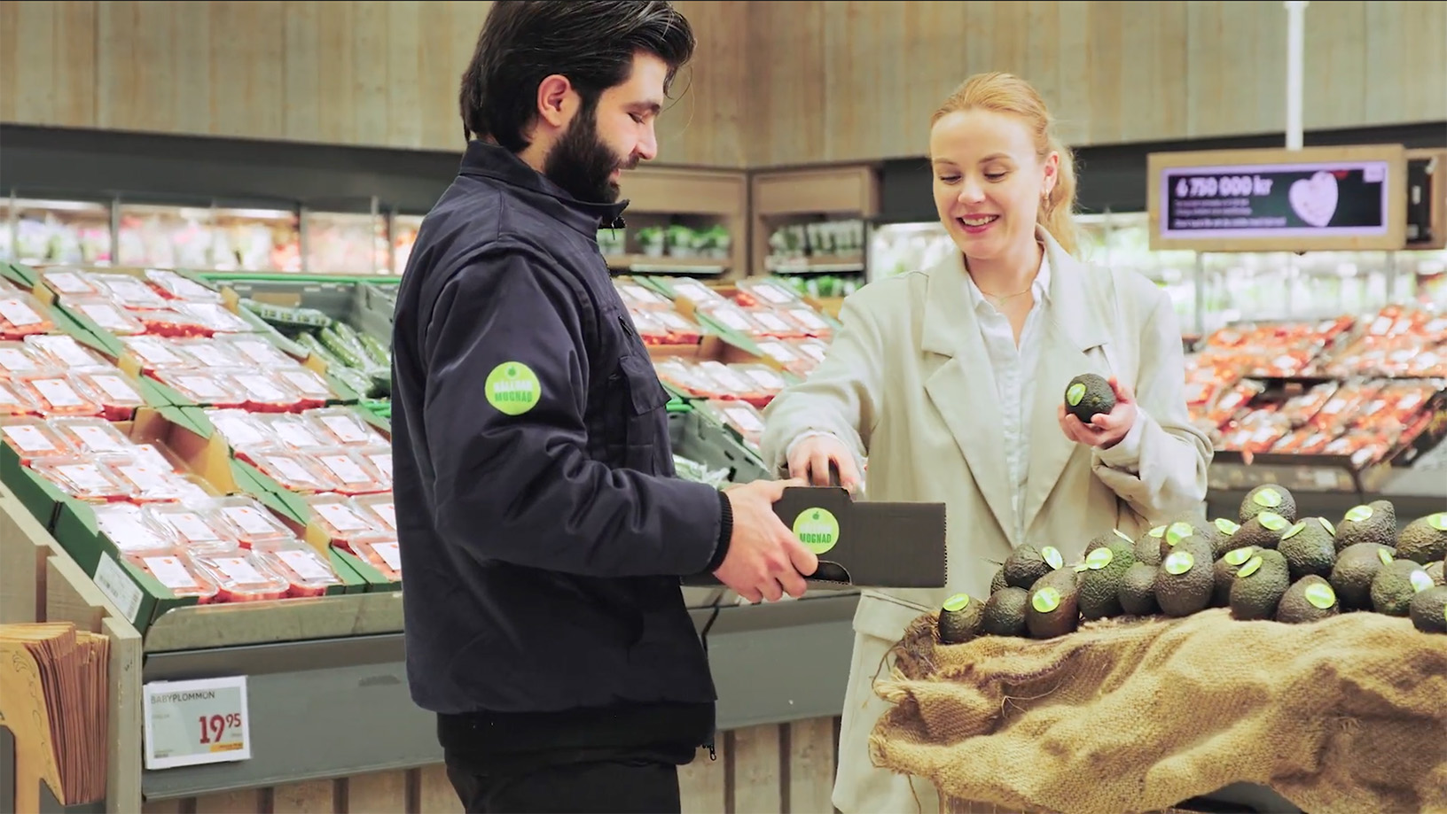 Screen-film-update En man från Swedlog kommer med nya avokados i affären som en kvinna gärna plockar av.